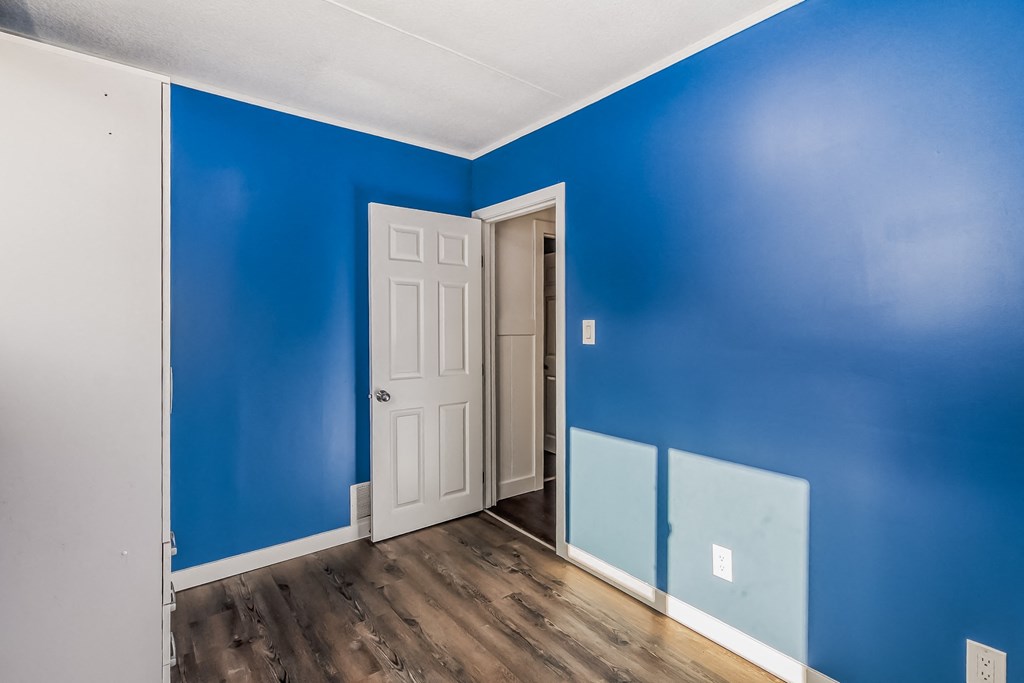 an empty room with blue walls and a white door