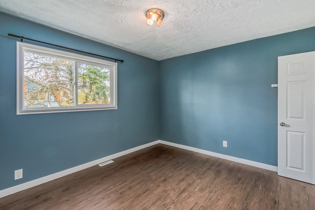 an empty room with blue walls and a window