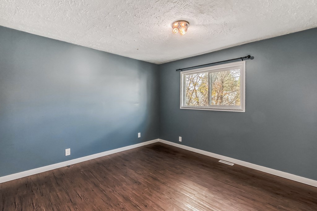 an empty room with blue walls and a window
