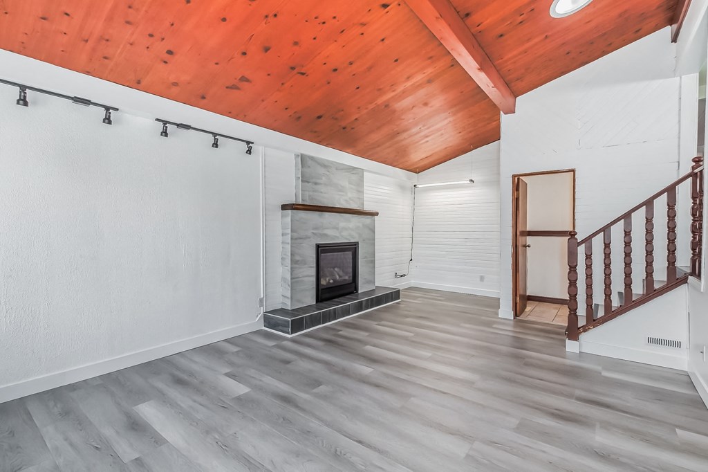 a living room with a fireplace and a wooden ceiling