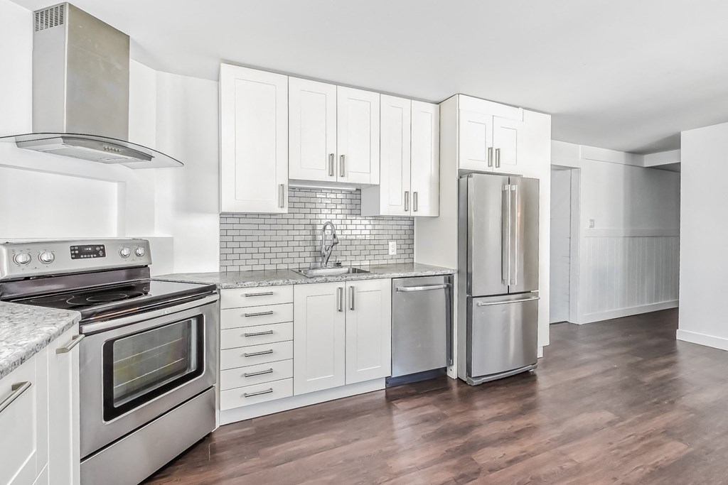 a white kitchen with stainless steel appliances and white cabinets