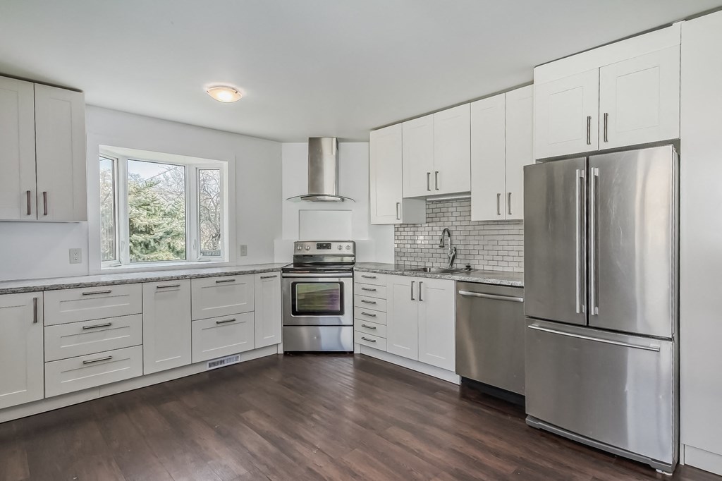 a white kitchen with stainless steel appliances and white cabinets