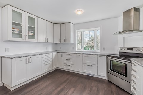 a kitchen with white cabinets and stainless steel appliances