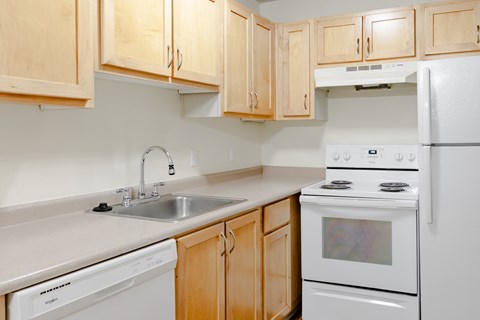 A kitchen with wooden cabinets and white appliances.