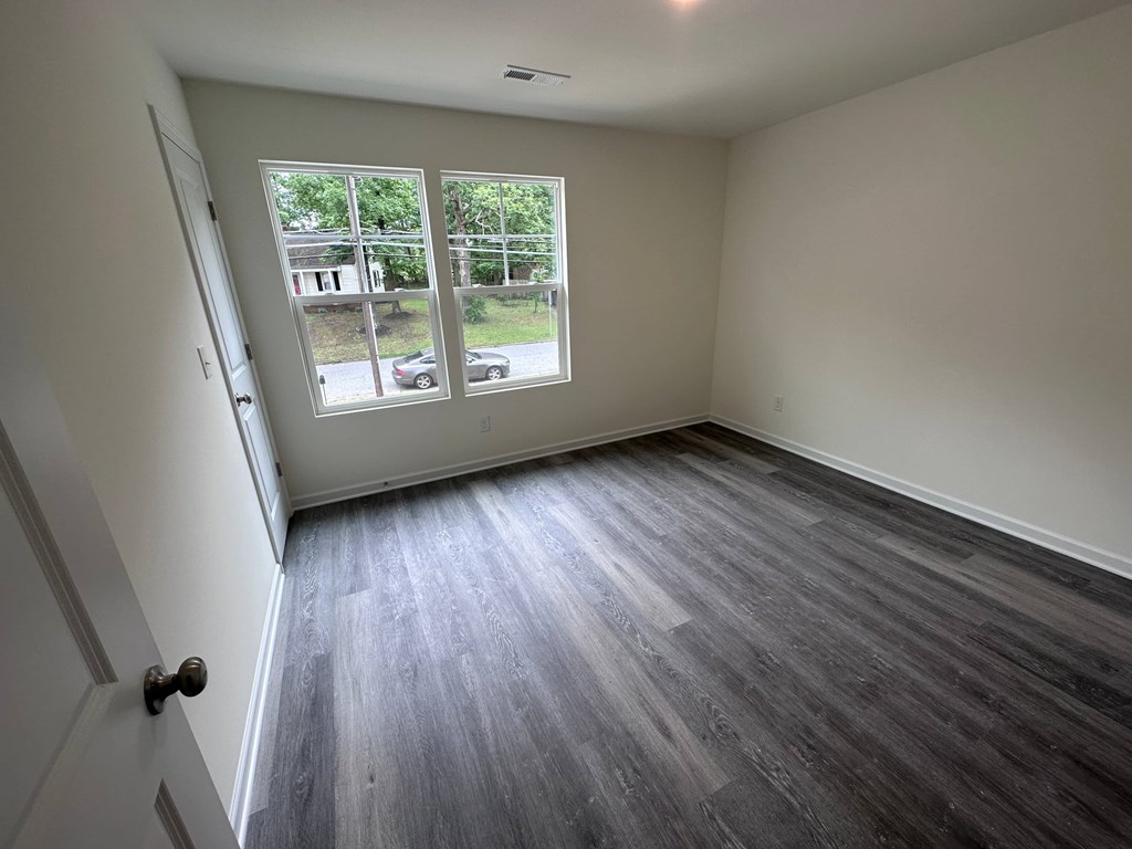 a empty room with wooden floors and a window