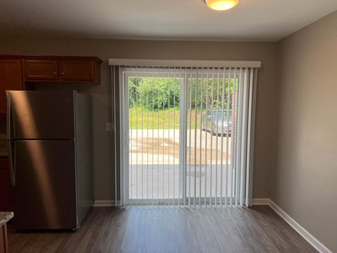 a living room with a sliding glass door and a refrigerator