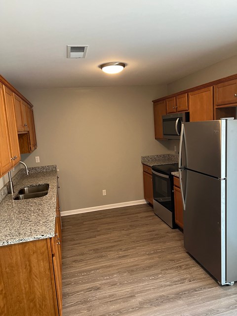 a kitchen with stainless steel appliances and wooden cabinets