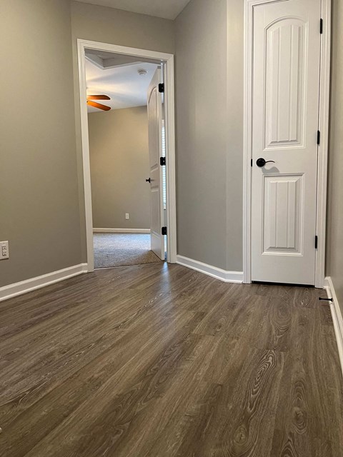a living room with wood floors and a white door