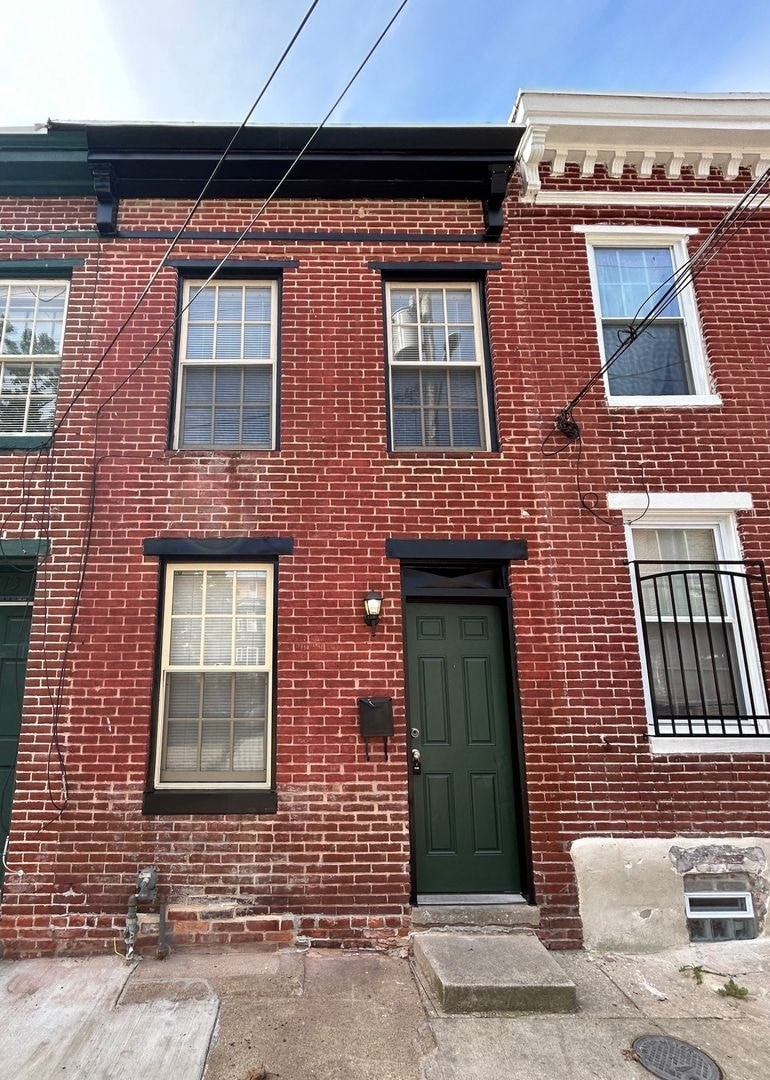 a red brick building with a green door