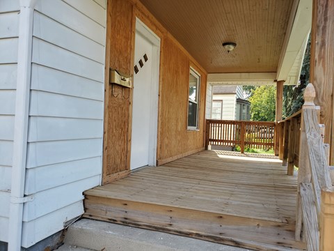 the front porch of a house with a wooden door