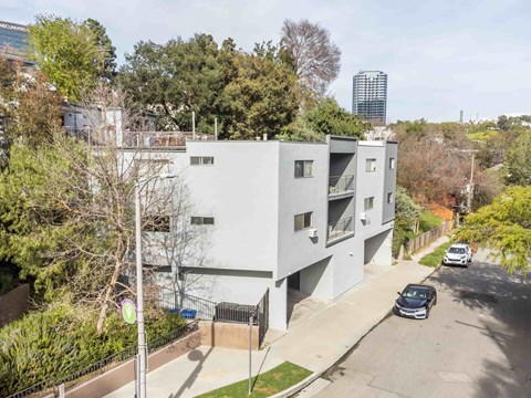 A modern apartment building with a car parked in front.