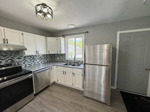 a kitchen with stainless steel appliances and white cabinets
