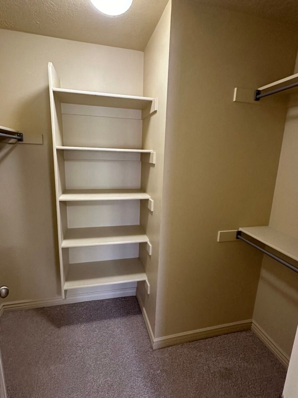 a small closet with empty shelves in a bathroom