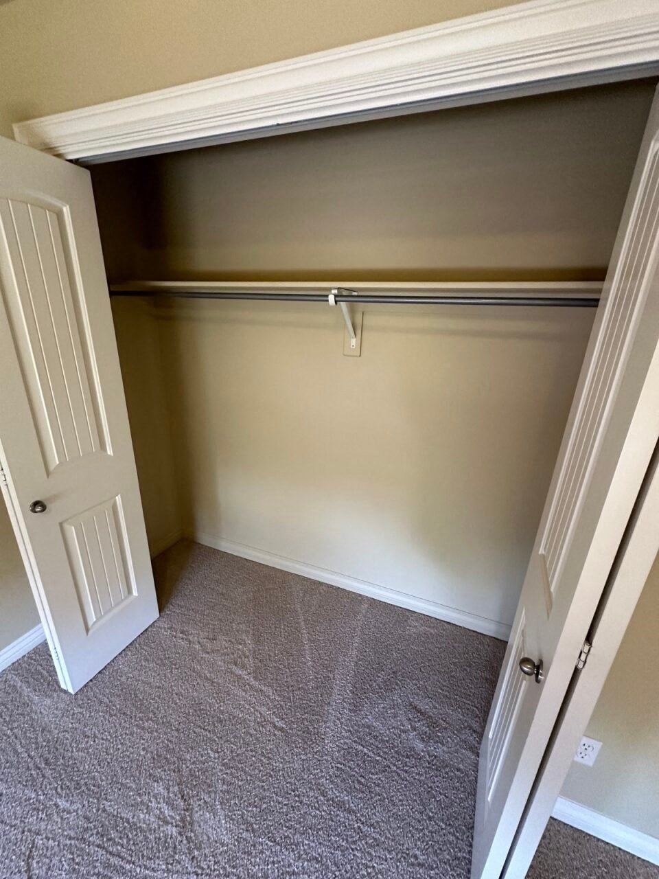 an empty closet with a door open to a closet