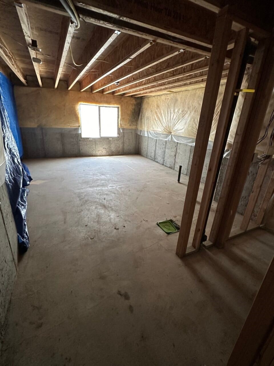 an unfinished basement with wooden beams in it