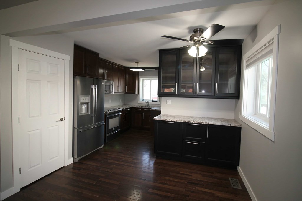 a kitchen with black cabinets and stainless steel appliances