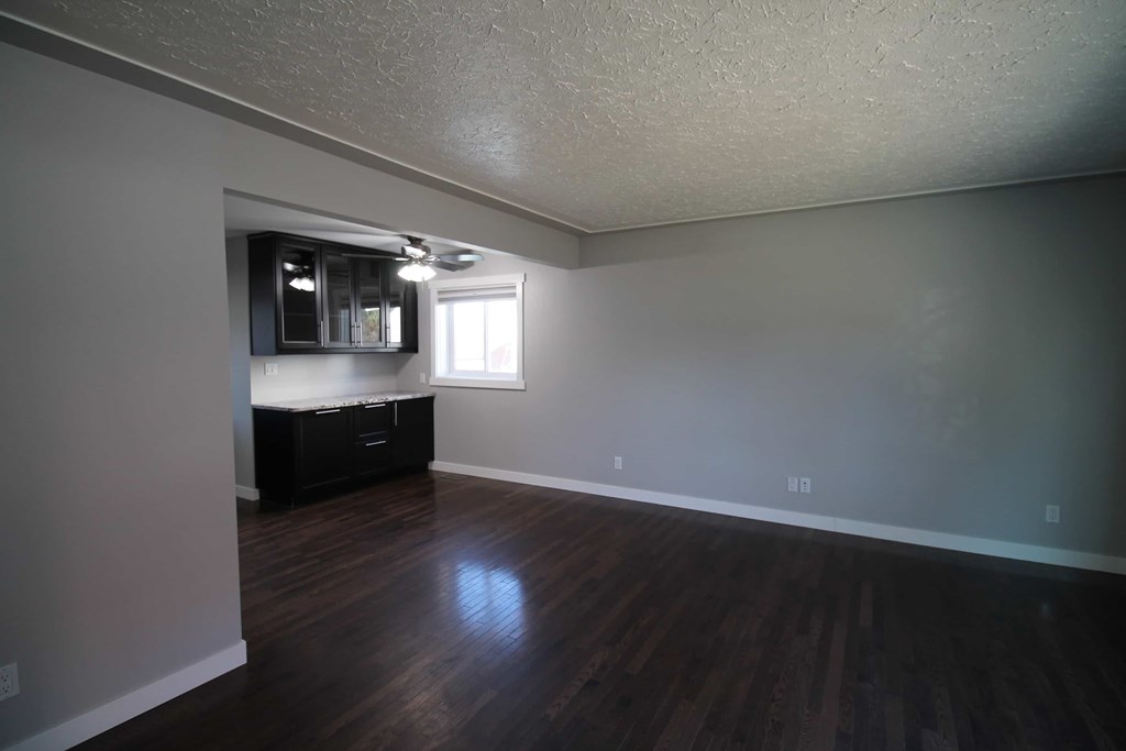 an empty living room with wooden floors and a window