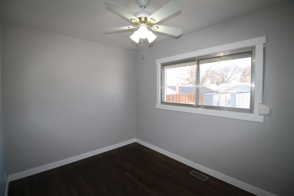 a room with a window and a ceiling fan