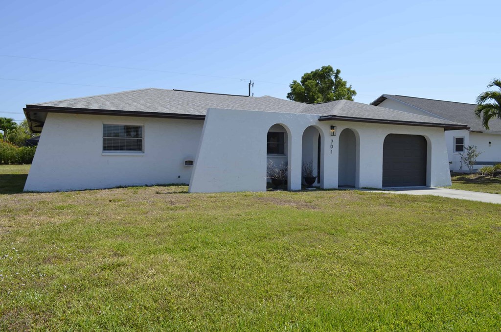 a white house with a lawn in front of it