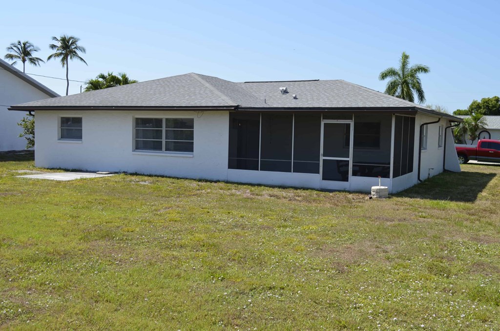 the front of the house with palm trees in the background