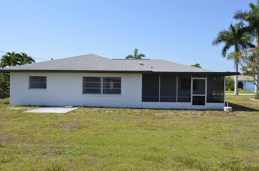 the front of the house with palm trees in the background