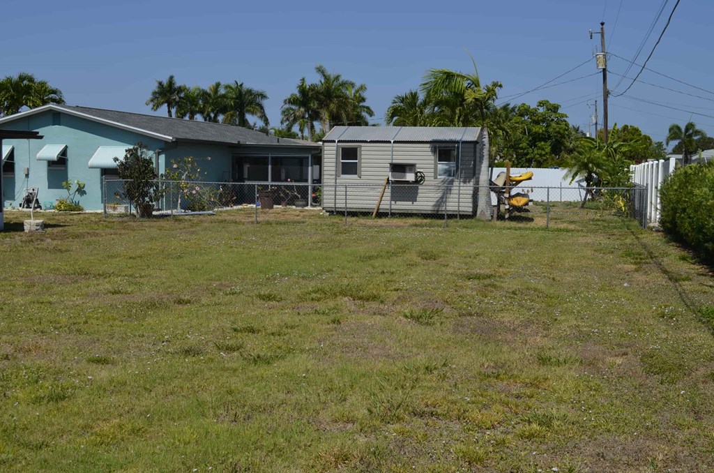 a house with a yard and a fence in front of it