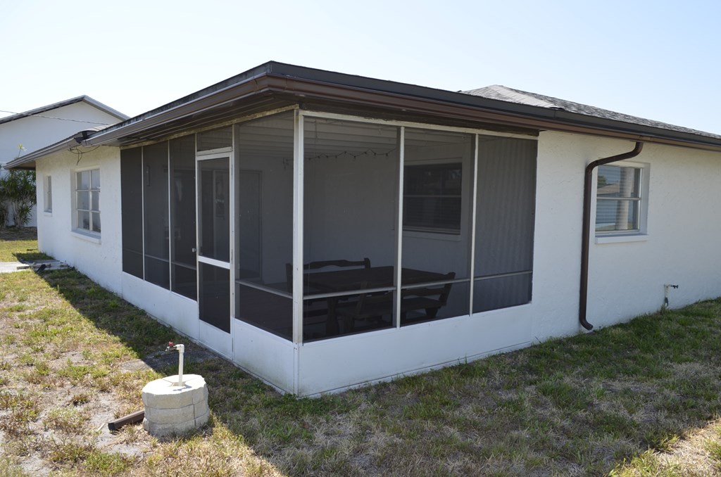 a screened in porch with glass doors and windows on a home