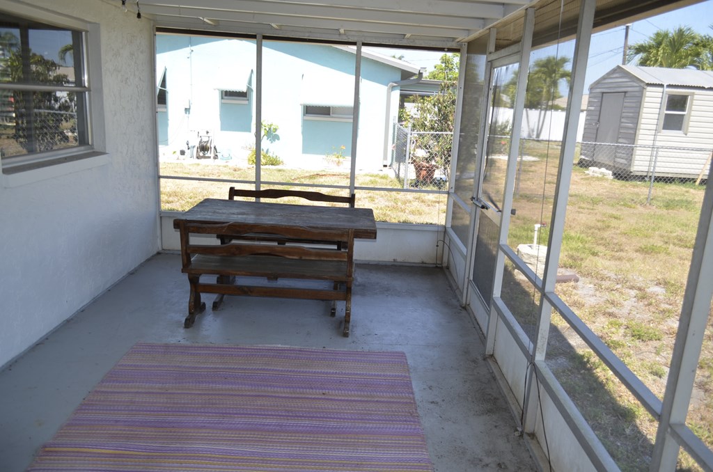 the screened in porch with a picnic table
