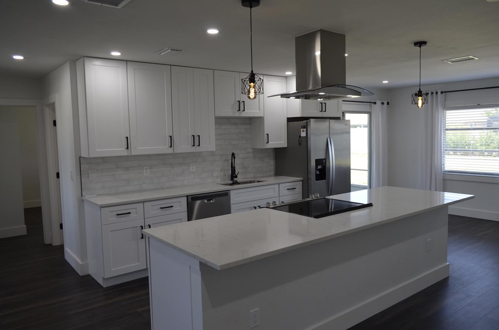 a white kitchen with white cabinets and a white counter top