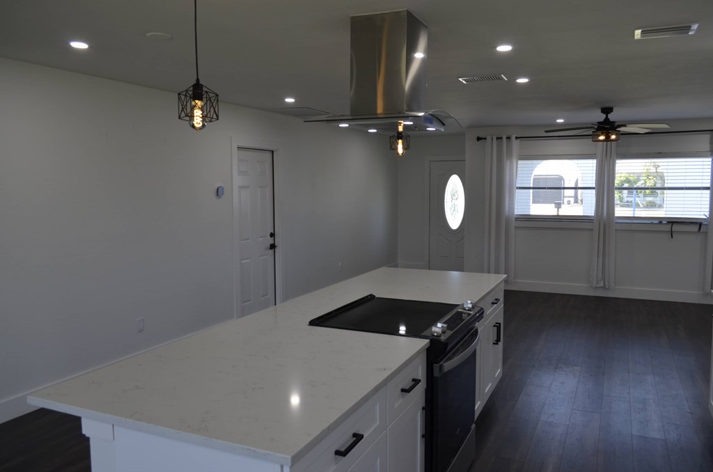 a kitchen with an island and a stove and a window