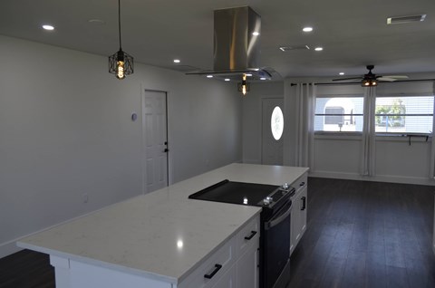 a kitchen with an island and a stove and a window