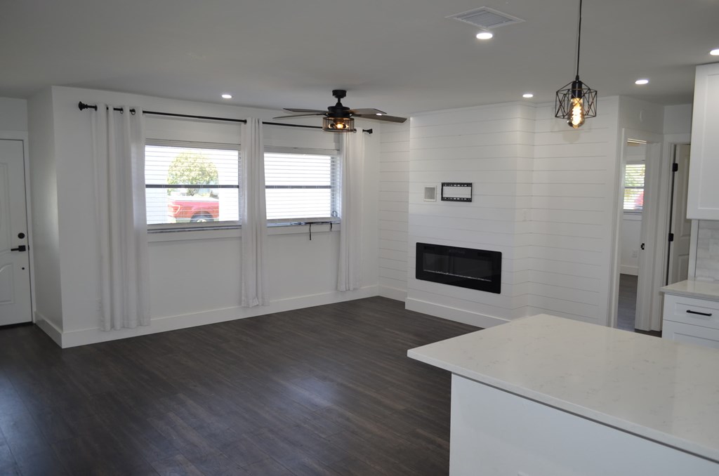 a white kitchen with a fireplace and a window