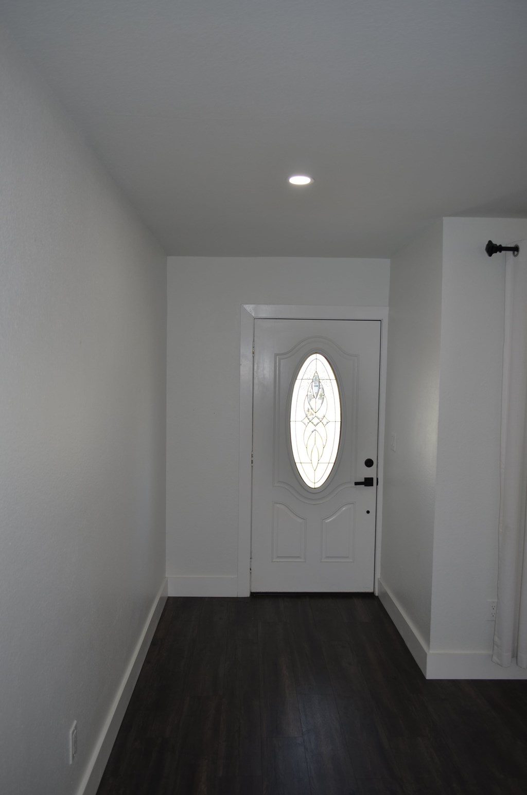 an empty room with a white door and a window