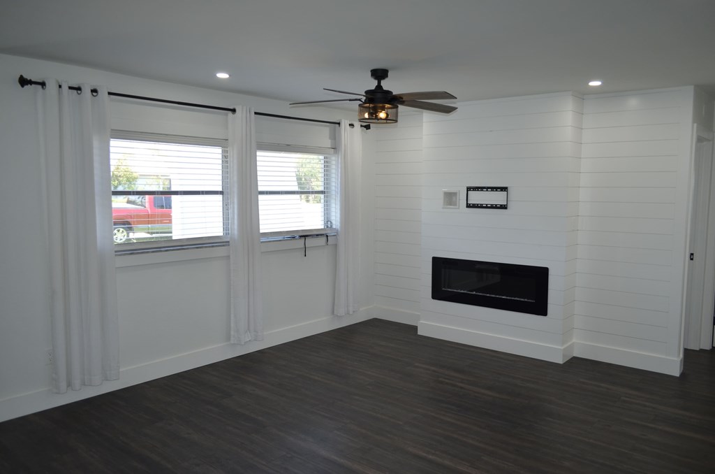 a living room with a fireplace and a ceiling fan