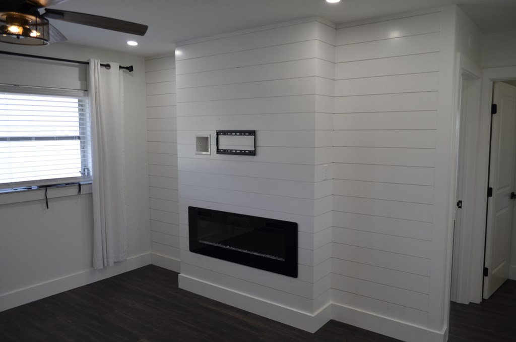 a white living room with a fireplace and a window