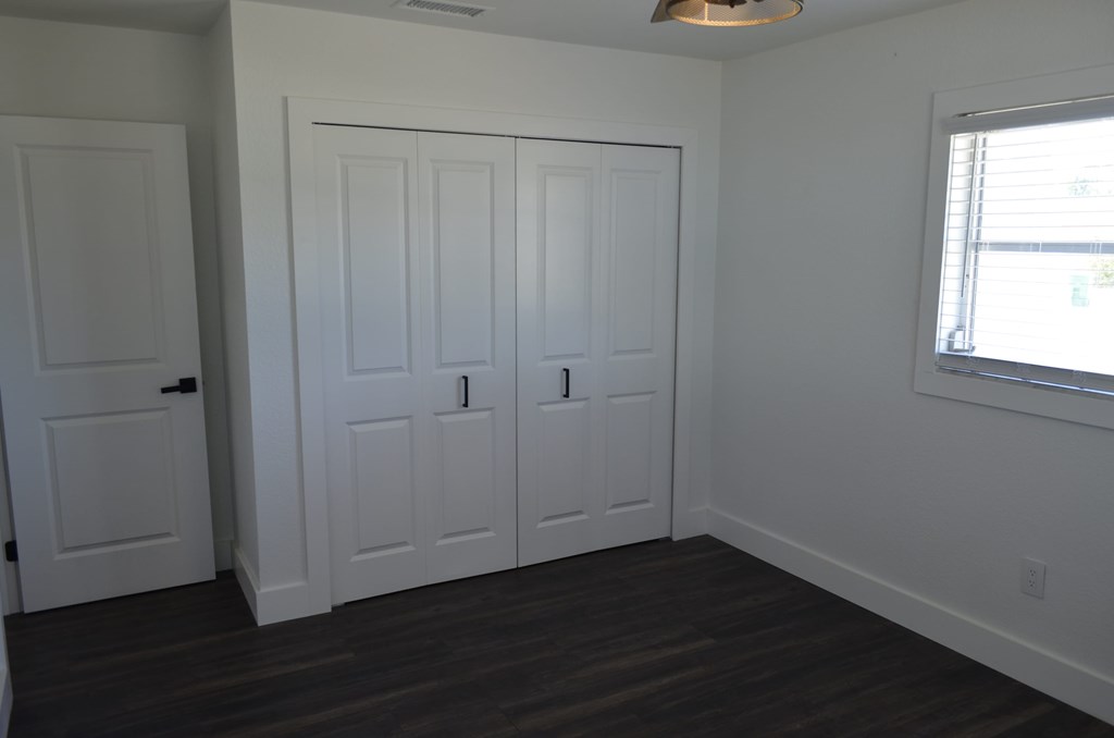 an empty room with two closets and a window