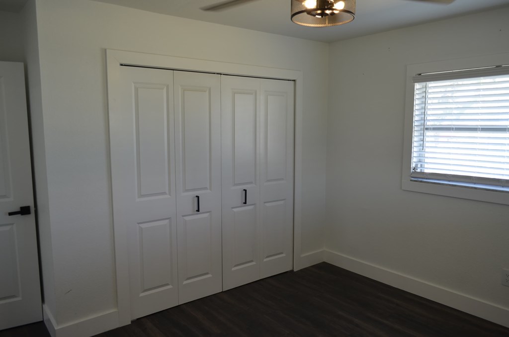 an empty room with two closets and a window