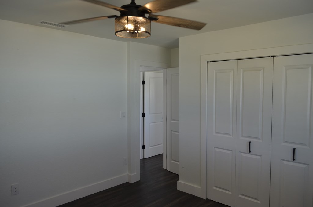 a bedroom with two closets and a ceiling fan