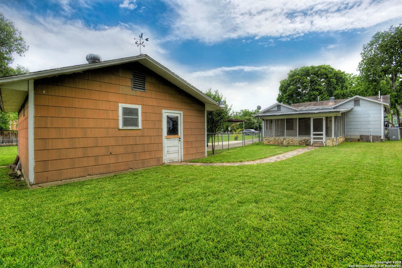 a backyard with a house and a yard with grass