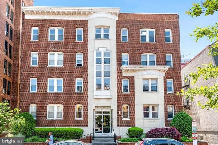 a brick building with two cars parked in front of it