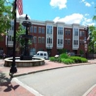 a city street with a building and a fountain