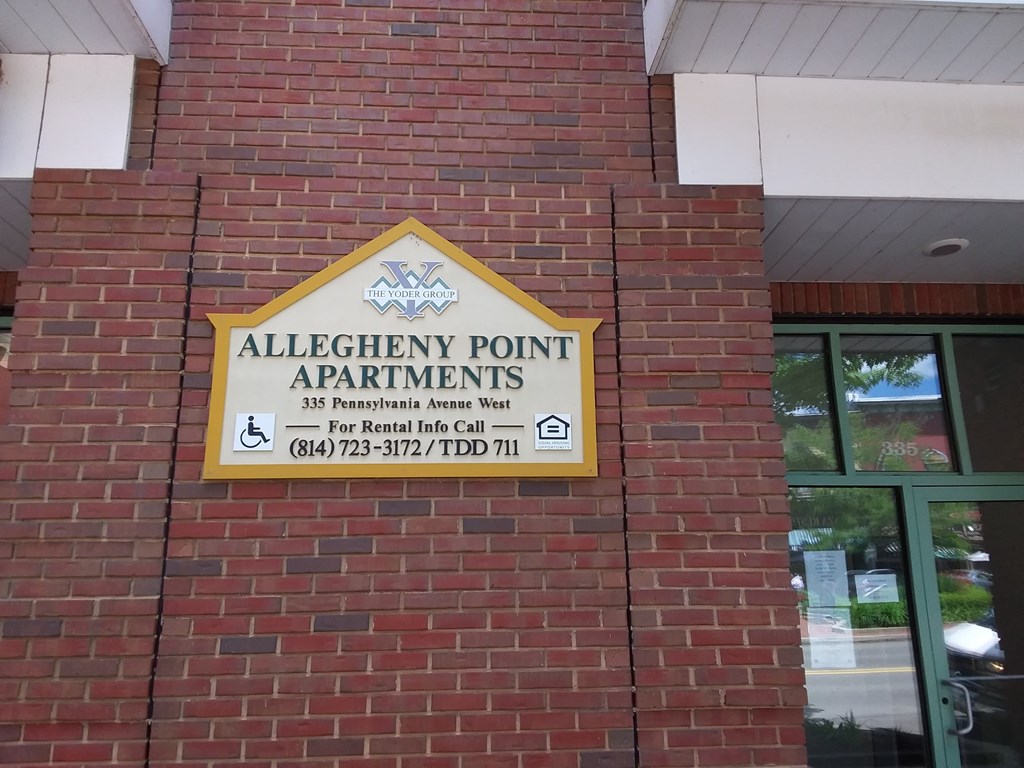 a sign on the side of a brick building saying allegheny point apartments