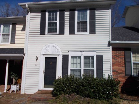 a white house with black shutters and a black door