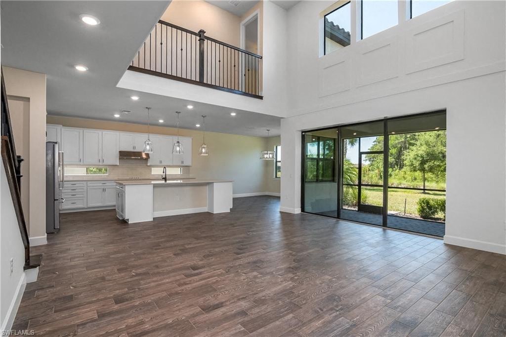 an open living room with a kitchen and a large glass door