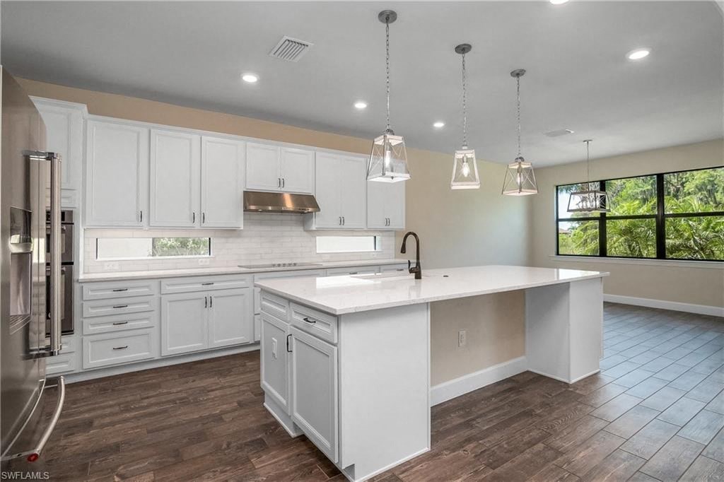 a large white kitchen with a large center island