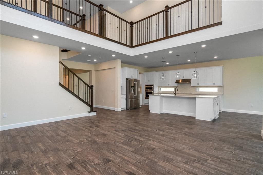 an open kitchen and living room with a staircase