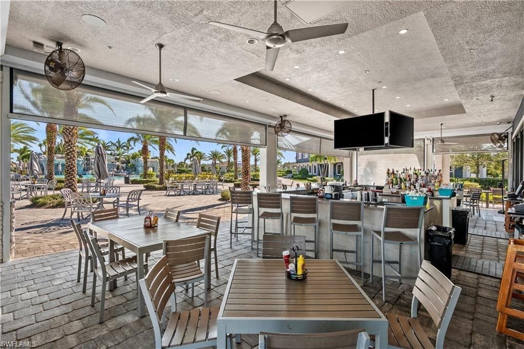 a restaurant with tables and chairs and a patio with palm trees