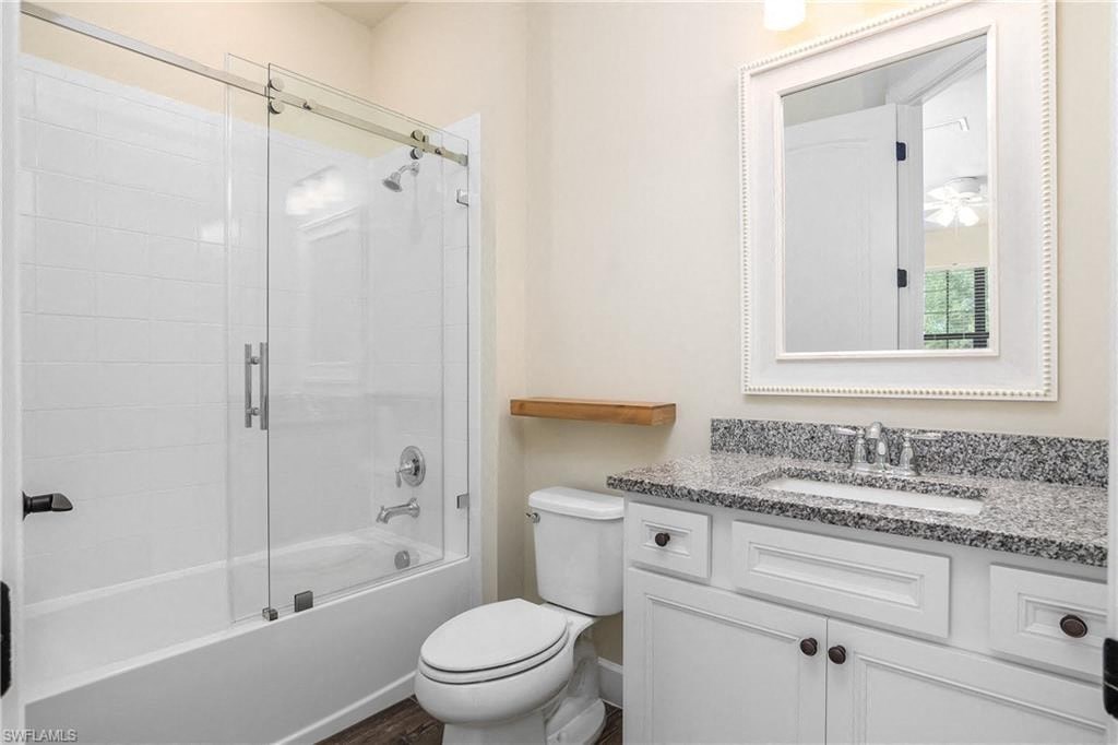 a white bathroom with a shower toilet and sink