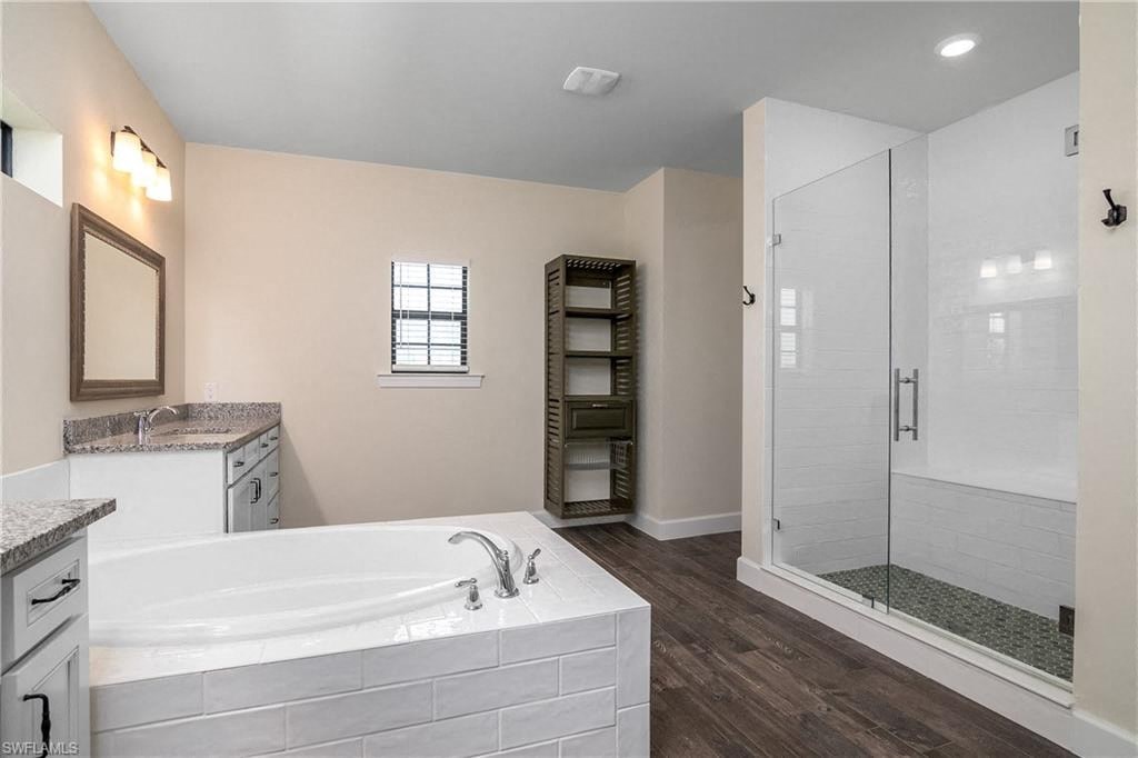 a white bathroom with a large tub and a shower