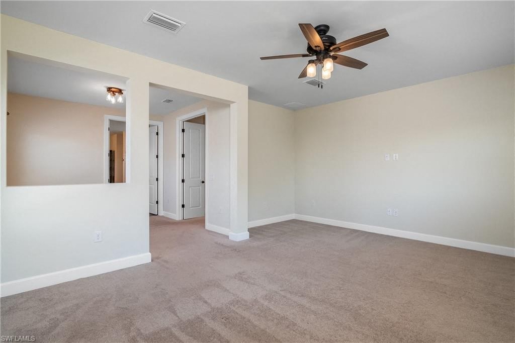 an empty living room with a ceiling fan